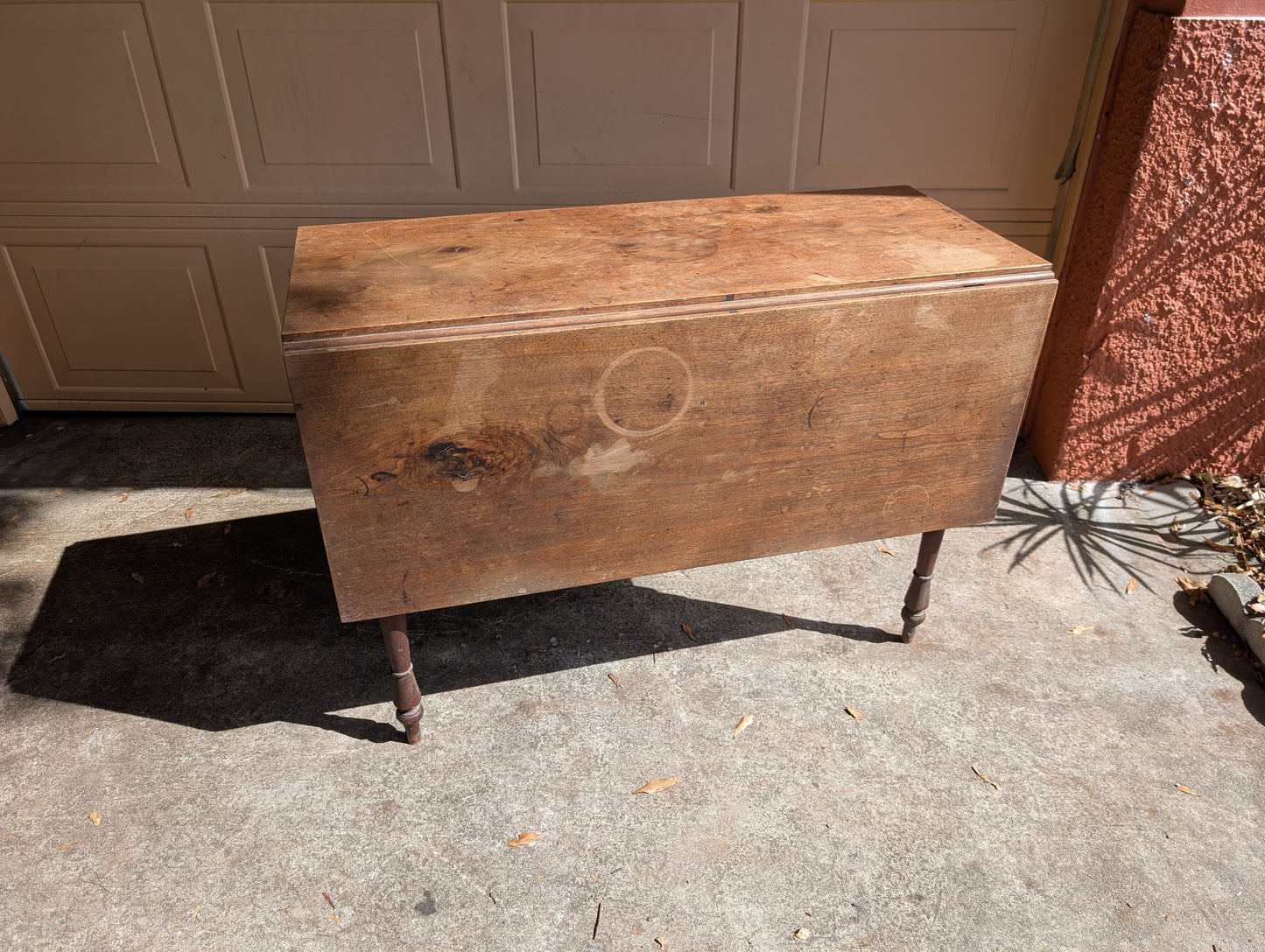 Antique wooden dining table with folding leaves